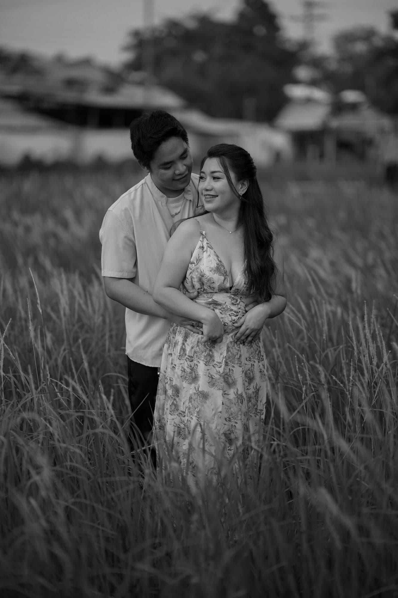 RK holding Ina from behind in a field of tall grass